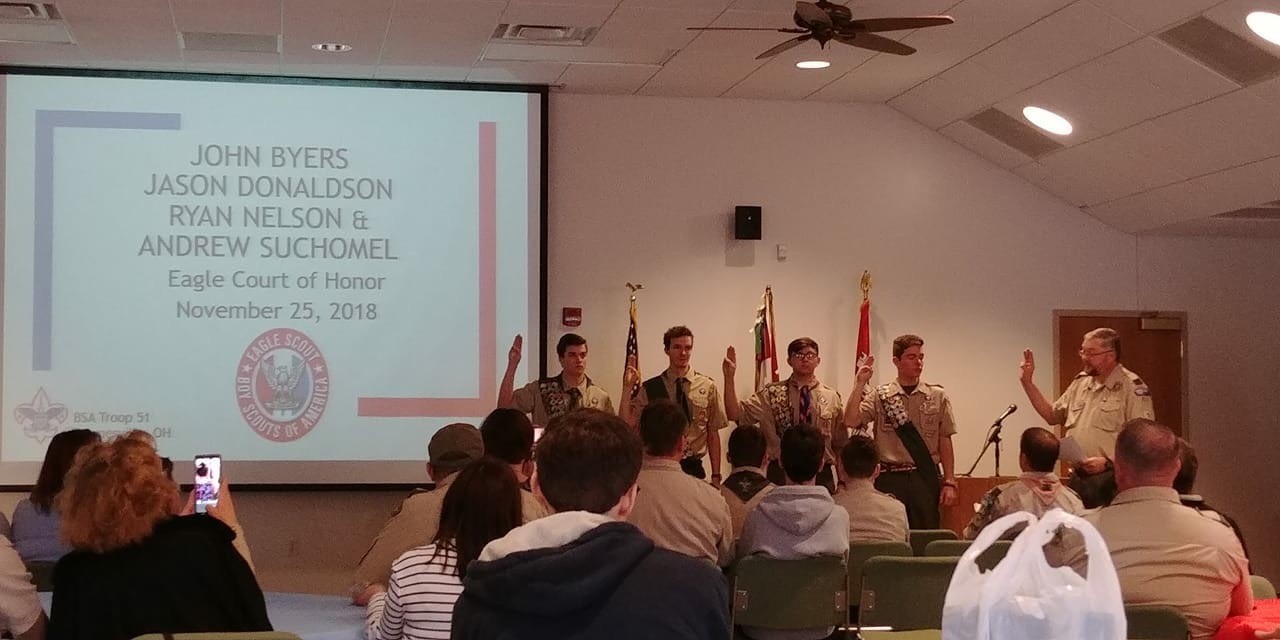 young men wearing uniform and taking oath